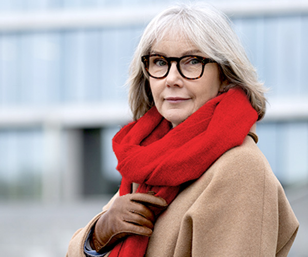 Elderly woman wrapped in a red scarf looking serenely at the camera