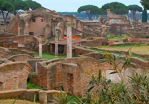 Ruins of the Ostia Antica Archaeological Park with ancient brick structures, columns and Mediterranean vegetation